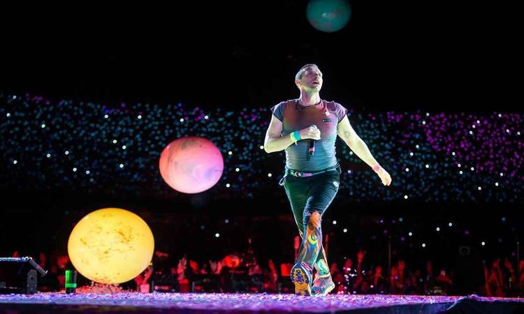 O vocalista do Coldplay, Chris Martin, caminha pelo palco