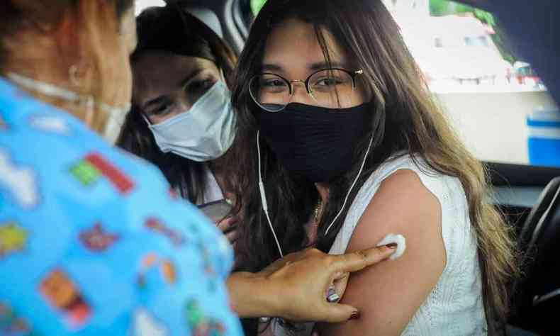Laura Campos de Carvalho, de 13 anos, tomando a primeira dose da vacina 