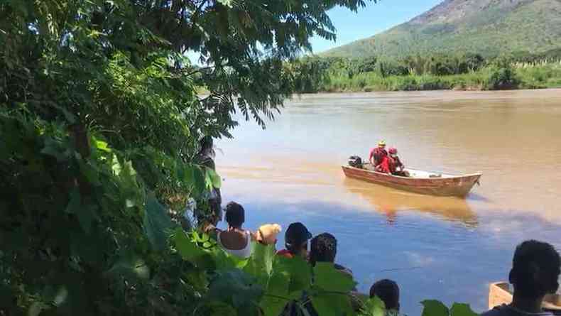 Moradores do Bairro So Pedro assistem  ao dos bombeiros nas guas do Rio Doce, para retirar o corpo de um homem que estava boiando no rio