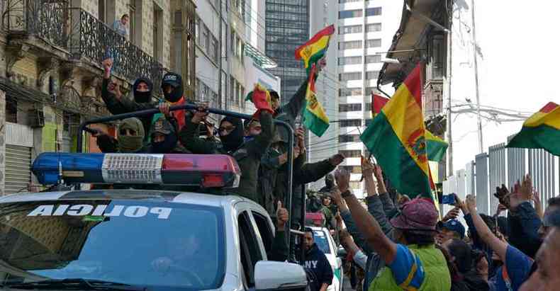 Policiais de La Paz com bandeiras da Bolvia aderem  rebelio com o apoio dos manifestantes da oposio (foto: Aizar RALDES/AFP )