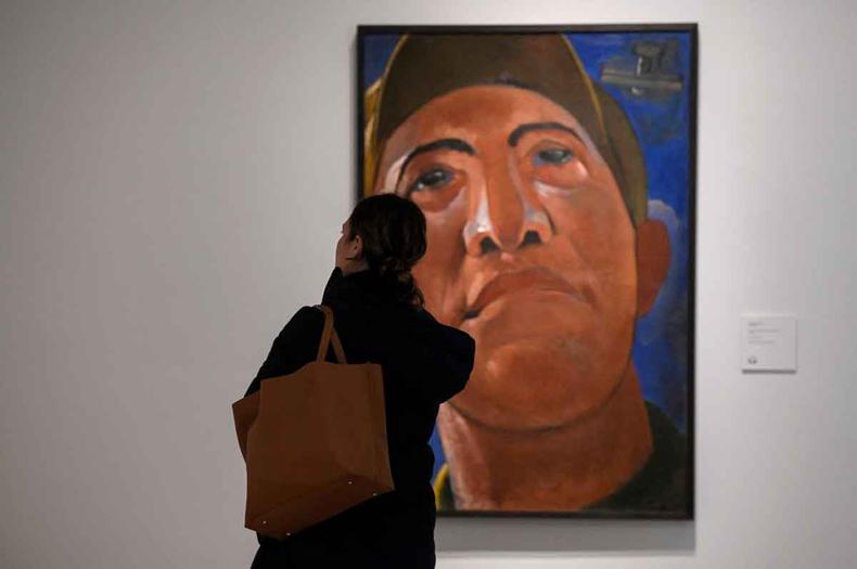 Uma jornalista observa de p a tela 'Portrait', de Kostiantyn Yeleva, em visita guiada para a imprensa  exposio 'No olho do furaco', em Madri 