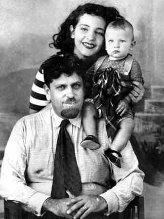 Escritora Patrcia Galvo, a Pagu, sorri, atrs de Oswald de Andrade, que est sentado. Rud, filho deles, est sentado no ombro do pai