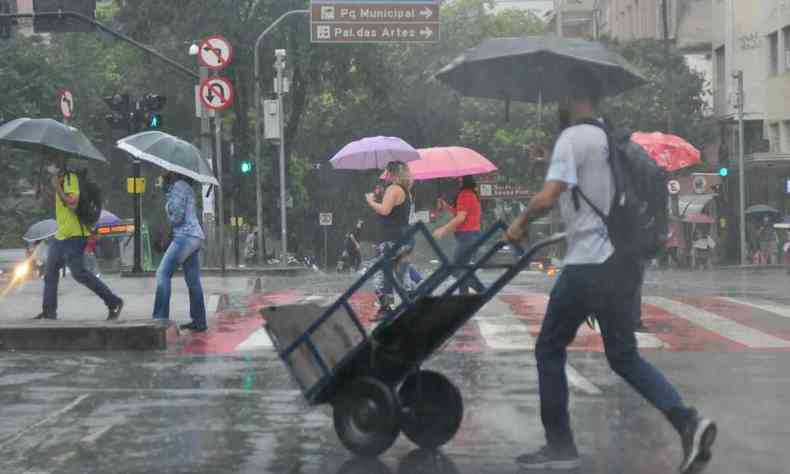  Pessoas usam sombrinhas para se protegerem da chuva na Praca Sete, no Centro.