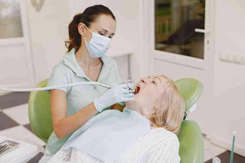 Idosa fazendo uma avaliação dos dentes com uma dentista 