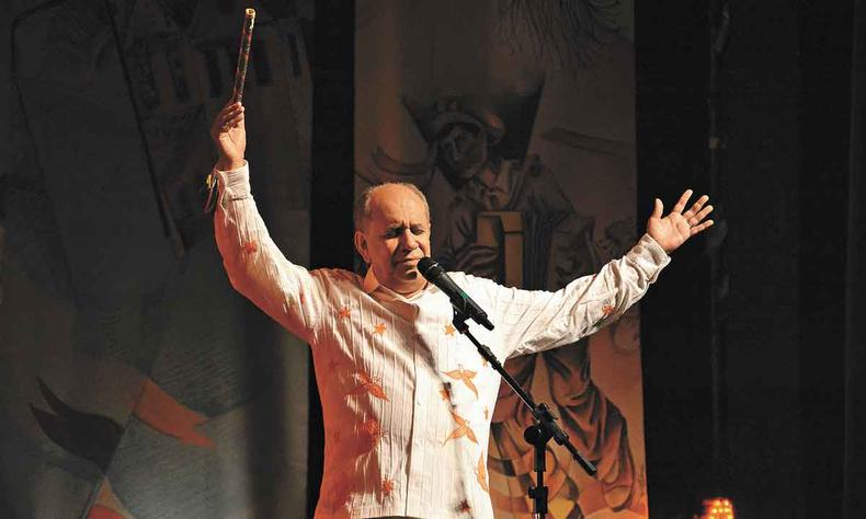 De camisa branca, Saulo Laranjeira abre os braos no palco 