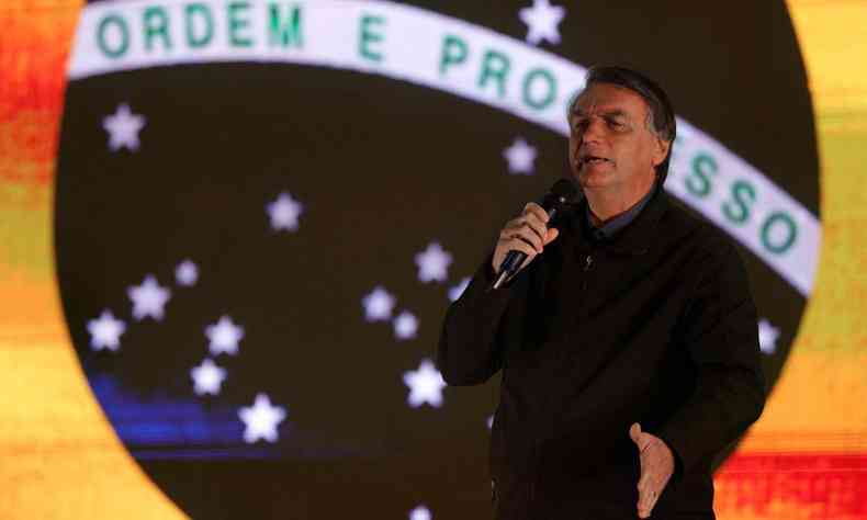 Jair Bolsonaro com bandeira do Brasil ao fundo