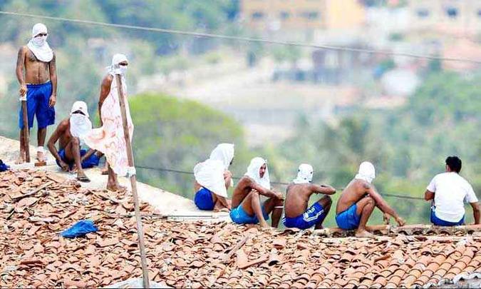 Presos encapuzados em Nísia Floresta (acima) e parentes em busca de notícias de detentos em penitenciária de Manaus: os dois motins, que deixaram mais de 90 mortos, completaram um ano(foto: Andressa Anholete/AFP - 12/01/17) Presos encapuzados em Nísia Floresta (acima) e parentes em busca de notícias de detentos em penitenciária de Manaus: os dois motins, que deixaram mais de 90 mortos, completaram um ano(foto: Andressa Anholete/AFP - 12/01/17)