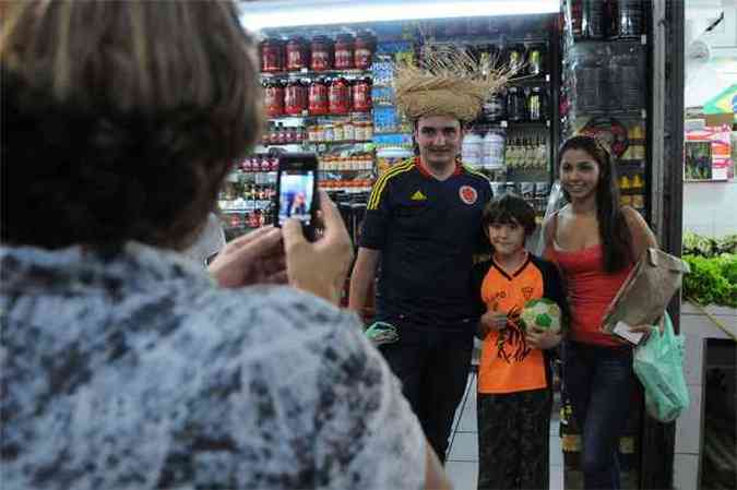 Confraternizao no Mercado Central: o pequeno Lucas, de 10 anos, fez questo de tirar foto com os colombianos Wilfrand e Marisol (foto: Tulio Santos/EM/D.A Press. Brasil)