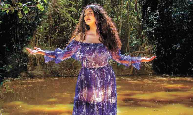 Cantora Aline Calixto est de braos abertos dentro de um rio na foto de lanamento de seu disco dedicado aos orixs 
