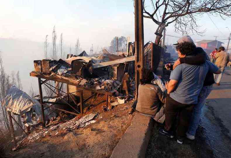 Desoladas, vtimas de incndio veem o que sobrou de suas casas destrudas pelo fogo (foto: Pablo Rojas Maradiaga / AFP)