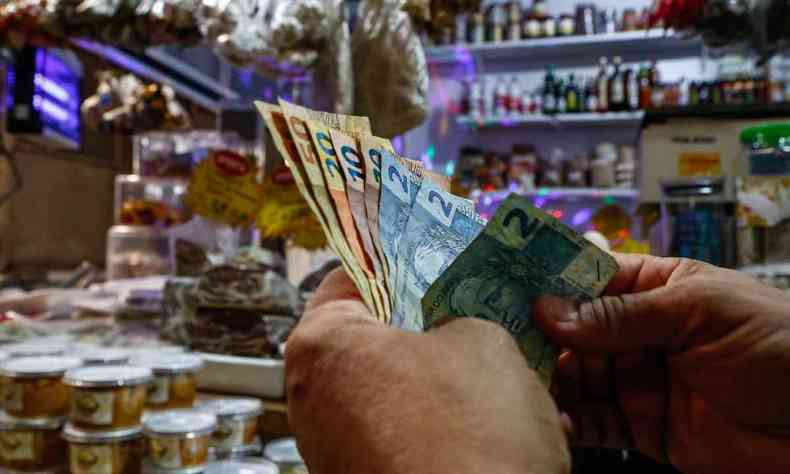 Um cliente conta dinheiro em um mercado em Salvador, Estado da Bahia, Brasil, em 26 de agosto de 2022