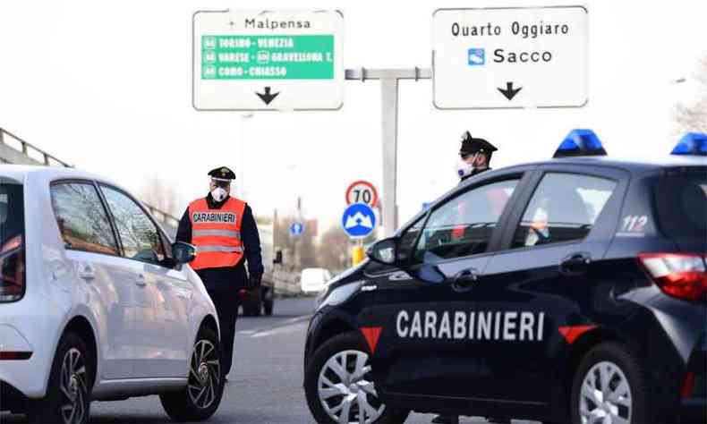 Policiais com mscaras na Itlia: mineiro relata que a regra  s sair para o trabalho e diz que o nvel de temor com a disseminao do vrus aumenta no pas(foto: Miguel Medina/AFP)