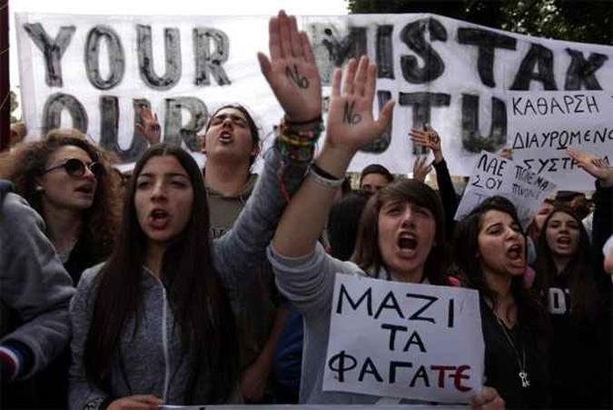 Jovens levantaram cartazes em oposição ao doloroso plano de resgate oferecido ao país(foto: PATRICK BAZ / AFP) Jovens levantaram cartazes em oposição ao doloroso plano de resgate oferecido ao país(foto: PATRICK BAZ / AFP)