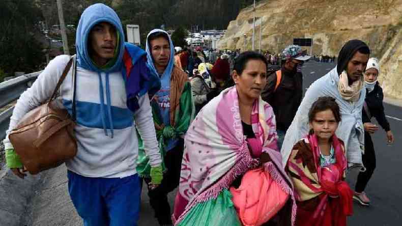 Migrantes venezuelanos caminhando em estrada
