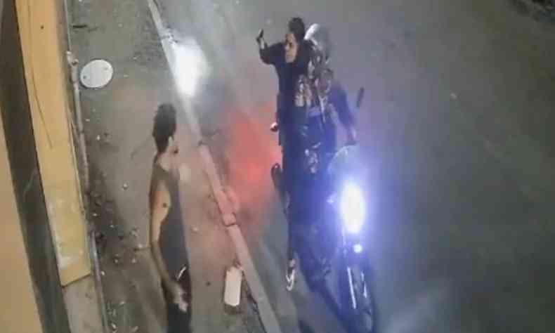 Daniel sendo abordado por duas mulheres em uma moto, com a passageira apontando uma arma