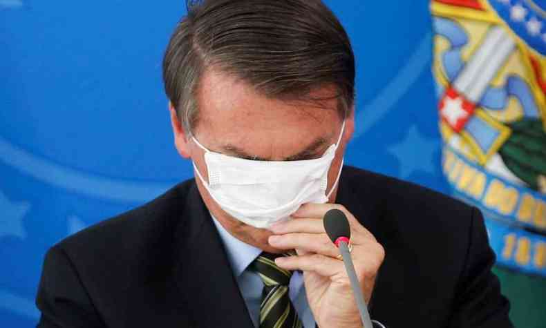 Bolsonaro coloca a mascara errado tampando os olhos