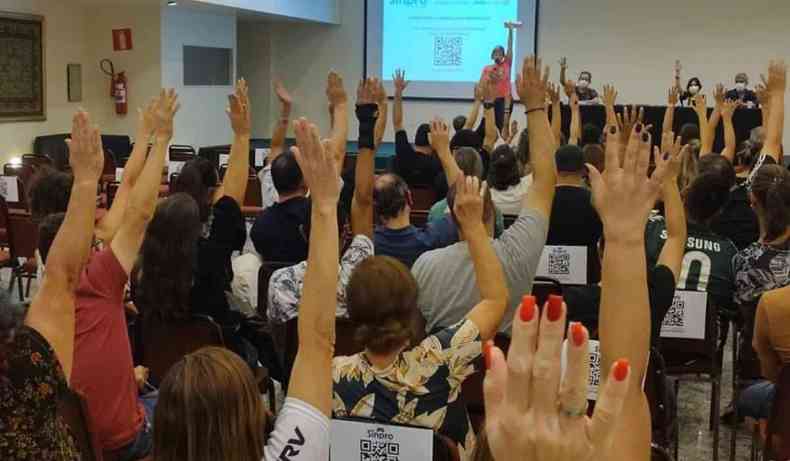 Professores votam favoráveis a paralisação, levantando as mãos, em assembleia