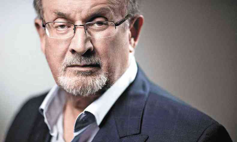 Vestindo camisa clara e palet escuro, Salman Rushdie encara a cmera 