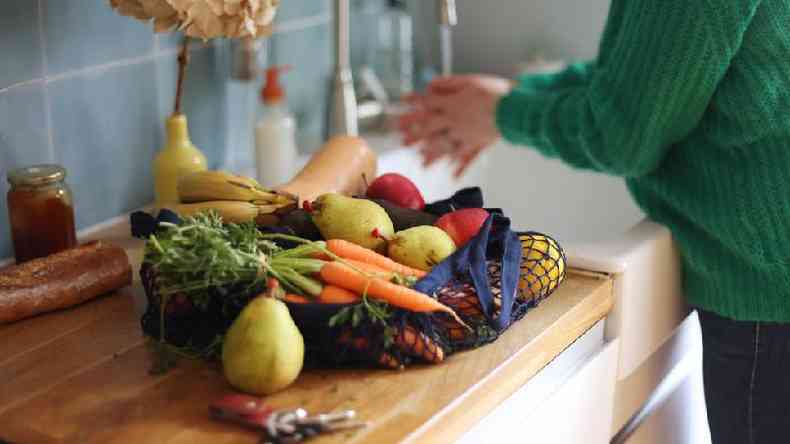 Mulher lavando frutas e legumes