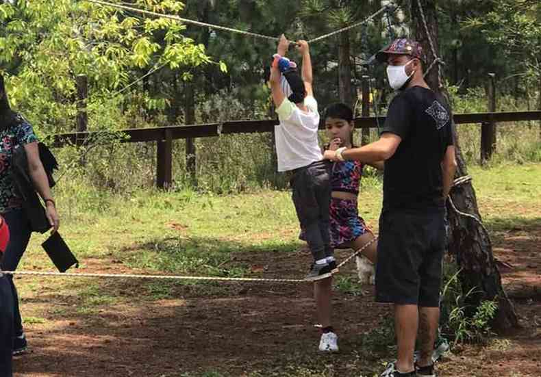 Pai e filho brincam entre as rvores do local onde querem um parque linear na linha frrea entre Belvedere e Vila da Serra 