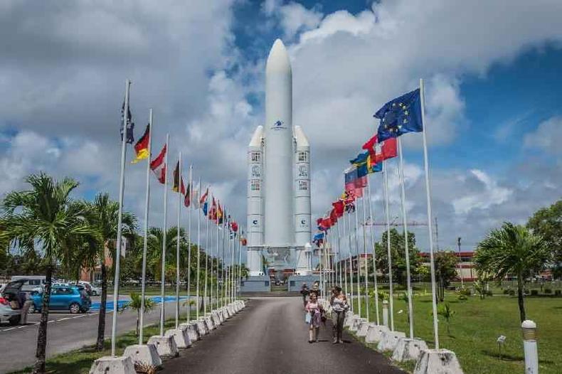 Foguete  visto enquadrado entre bandeiras numa base de lanamento