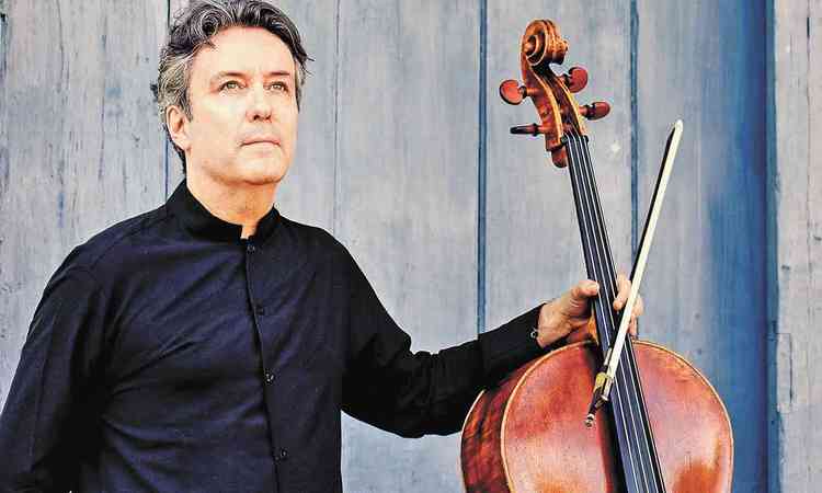Matias de Oliveira Pinto, vestido de preto, segura o violoncelo com a mo esquerda
