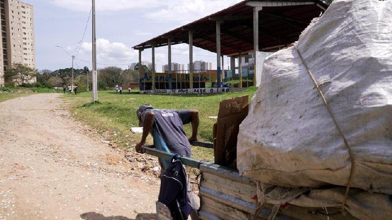 Elias diz que ter vergonha de ser catador e que familiar já disfarçou para não cumprimentá-lo na rua(foto: BBC) Elias empurrando carrinho com reciclagem em terreno em Guarulhos
