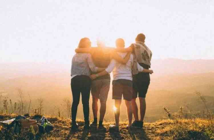 Amigos se abraando durante o pr-do-sol