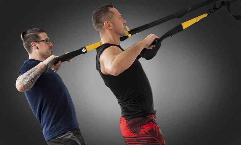 dois homens em um aparelho de elstico fazendo exerccio para os braos