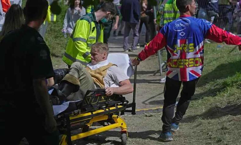Homem é socorrido após se machucar em corrida de queijo(foto: NYPost/Reprodução) homem em maca recebendo primeiros socorros