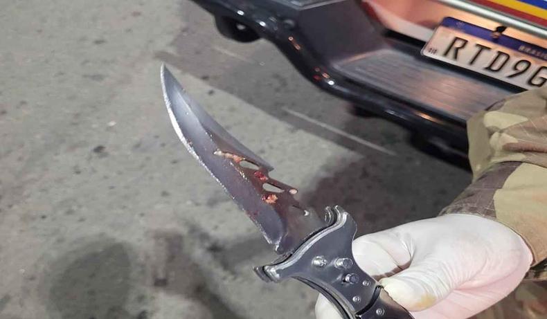 Faca suja de sangue nas mos de um policial