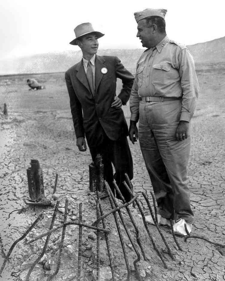 Robert Oppenheimer analisando com o general Leslie Groves os restos da torre de ao aps o teste Trinity em foto em preto e branco