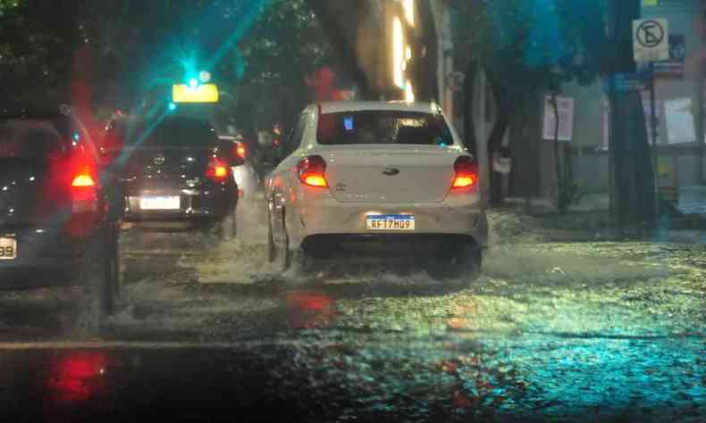 Carros trafegam sob forte chuva