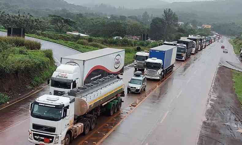 estrada com caminhes e outros veculos parados 