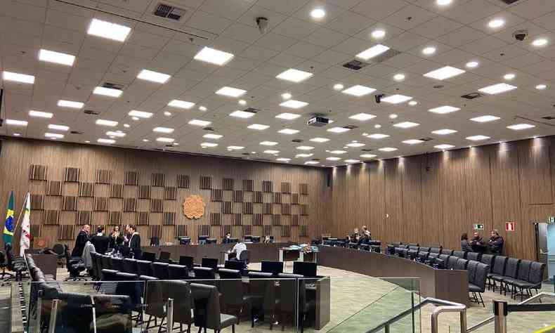 Tribunal do TJMG com vrias luzes acessas e juristas conversando