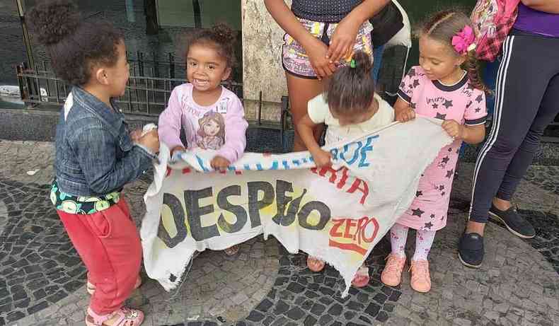 Foto de quatro crianas segurando uma faixa com os dizeres 'Despejo zero'.
