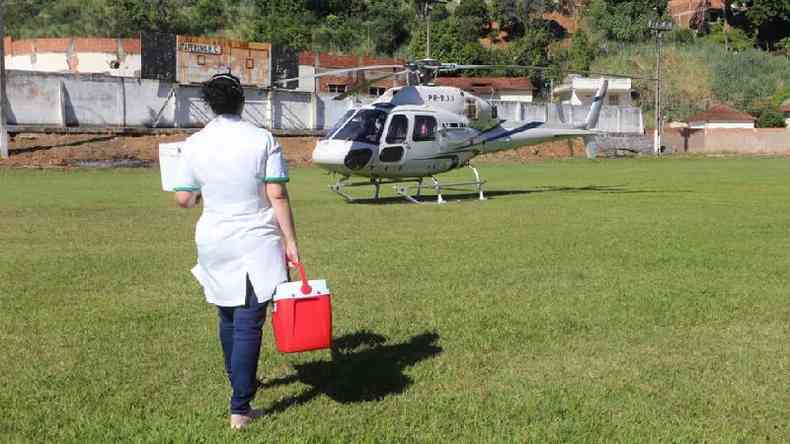 Profissional carrega rgo para transplante em caixa trmica em direo a helicptero