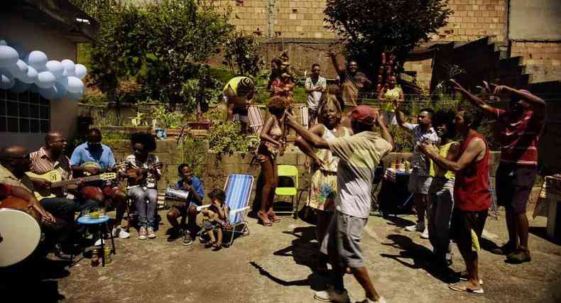 Foto do filme 'Marte Um' que mostra um grupo de pessoas em um quintal em uma festa regada a samba