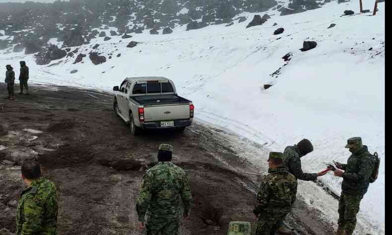 equipe de resgate vestindo uniformes camuflados em estrada ao lado de elevao de neve no Equador