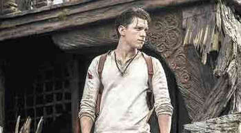 O ator Tom Holland est em p e olha para o lado em meio a pedras em cena do filme Uncharted fora do mapa 
