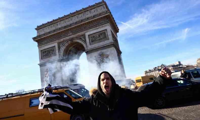 Um manifestante segura uma bandeira bret em frente ao Arco do Triunfo, nos Campos Elsios em Paris, em 12 de fevereiro de 2022, quando comboios de manifestantes chamados 'Convoi de la Liberte' chegaram  capital francesa