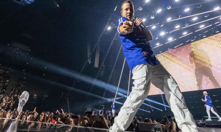 Musico Howie D, do Backstreet, est no alto do palco e aponta para a cmera
