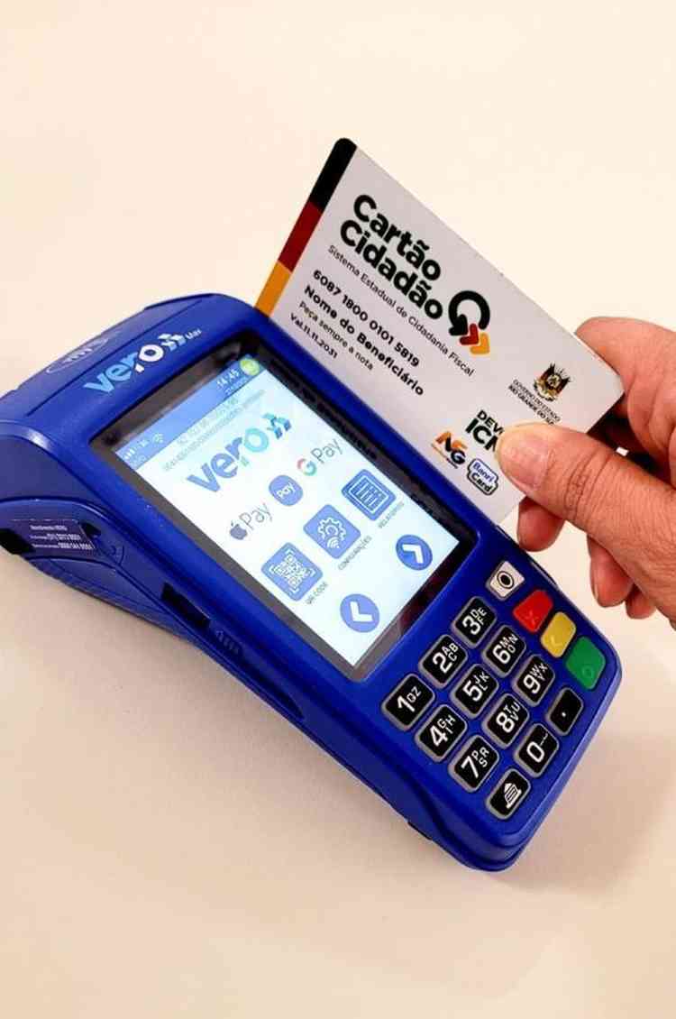 Pessoa passa carto do programa Devolve ICMS na mquina de pagamento