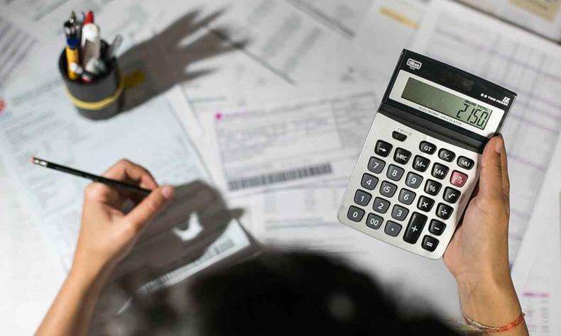 Pessoa fazendo contas com calculadora
