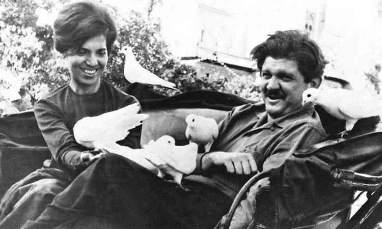 Eunice e Rubens Paiva sorriem numa charrete, com pombos no colo