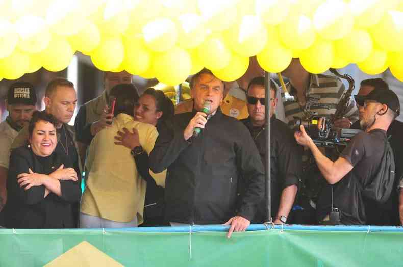 Bolsonaro fala com apoiadores em palanque nas cores verde e amarelo