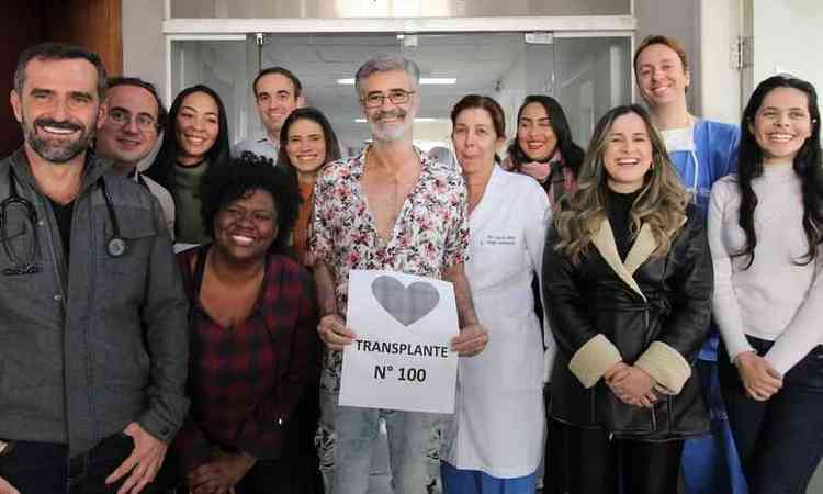 Equipe mdica do hospital Santa Casa BH e o paciente que recebeu o transplante, segurando uma papel escrito 'transplante nmero 100'