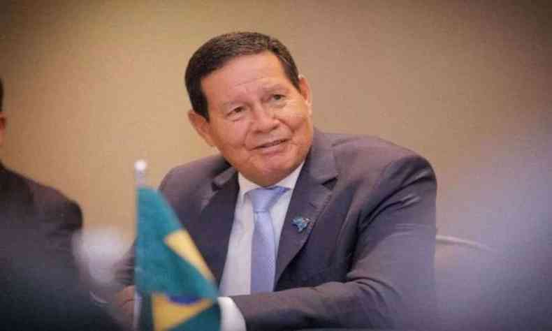 Vice-presidente sorri; à frente dele, uma pequena bandeira do Brasil