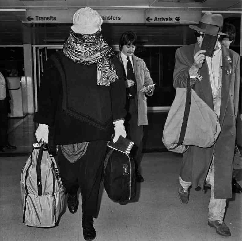 Cantor Boy George chega ao aeroporto de Heathrow em 1985, disfarando-se com um leno(foto: Getty Images)