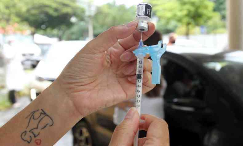 Profissional de saúde prepara a seringa para aplicação da vacina 